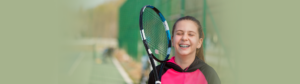 Girl with braces playing tennis. She needs orthodontic protection to protect her braces and teeth from an emergency dental sports injury,